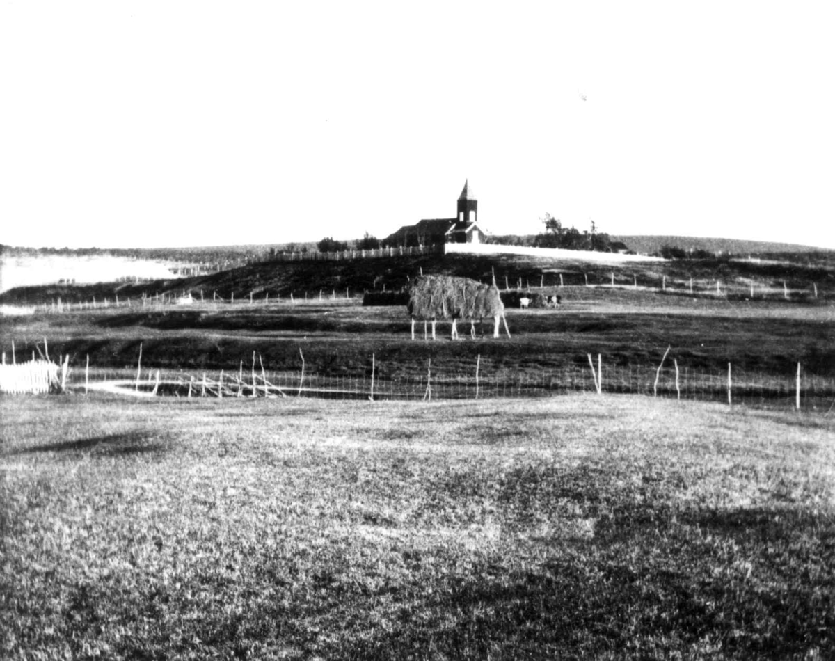 Kautokeino Kirke, en høystakk på engen foran kirken. 19.04.1910.