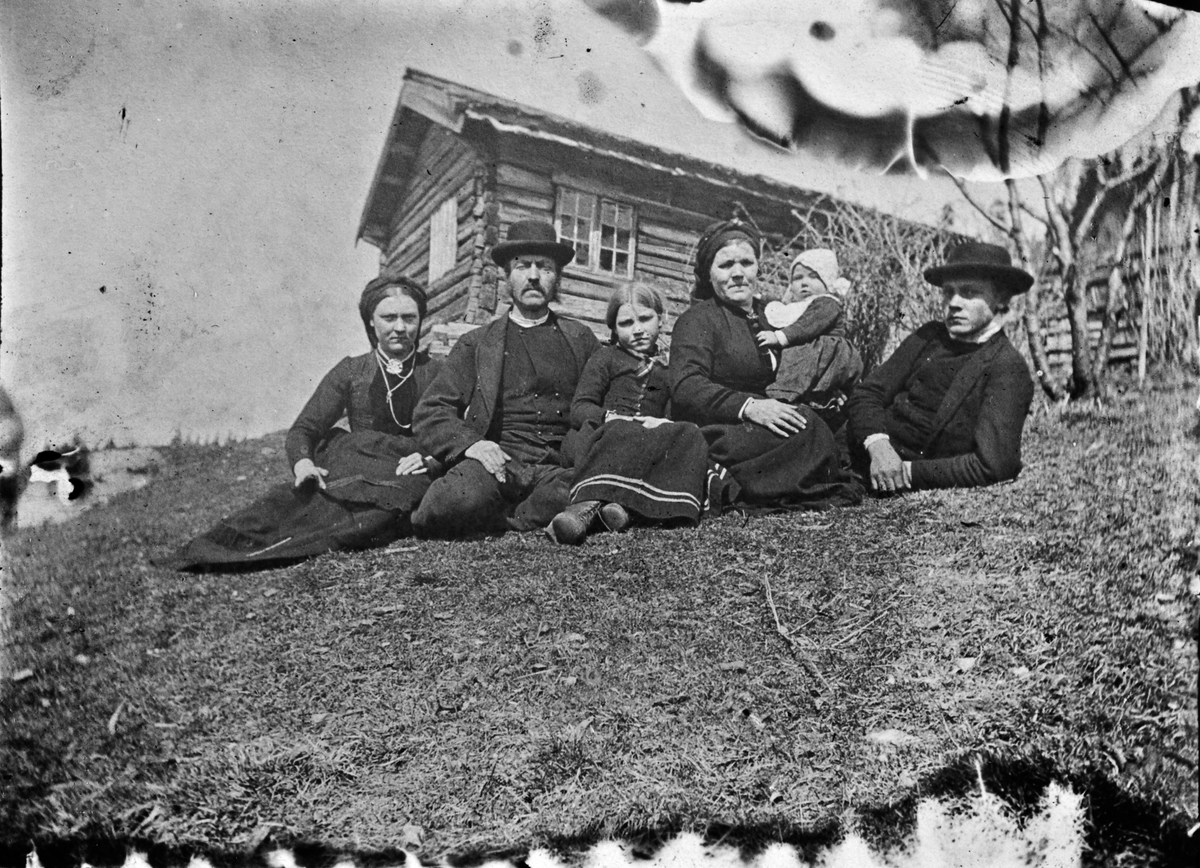 Familiegruppe på plassen/husmannsplassen Toen/Lundetoen som hørte til Lunden gård, Hegglandsgrend, Fyresdal, Telemark. Det kan være ekteparet Olav Auverson N. Toen (1853-1936) og Gunvor Ånundsdatter Bergedalen (1851-1932) som bodde på plassen til 1932, som her er fotografert sammen sønnen  Auver (1879-1947) til høyre. Han bodde på plassen år 1900 og var dagarbeider, og kjøpte plassen Granheim Gnr. 50/11 i 1908. Muligens har han her med kona, Tone Tarjeisdtr. Kleiv (1881-) fra Nordskog/Skræi og to barn.