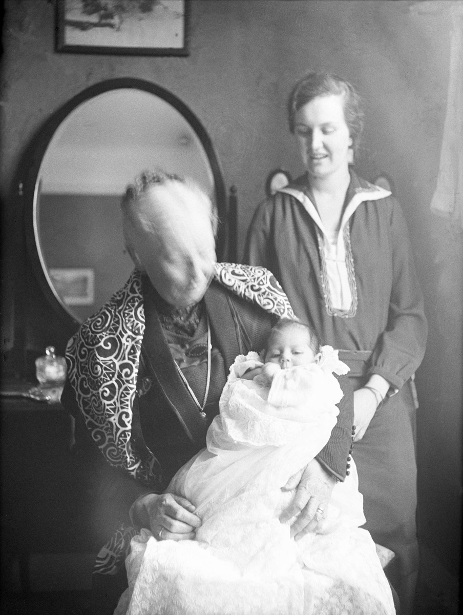 Tre generasjoner på dåpsdagen, mormor Andrea Leegaard sitter med sitt barnebarn Guri på fanget mens moren Dordi Arentz står bak. Fotografert 17 mars 1929.