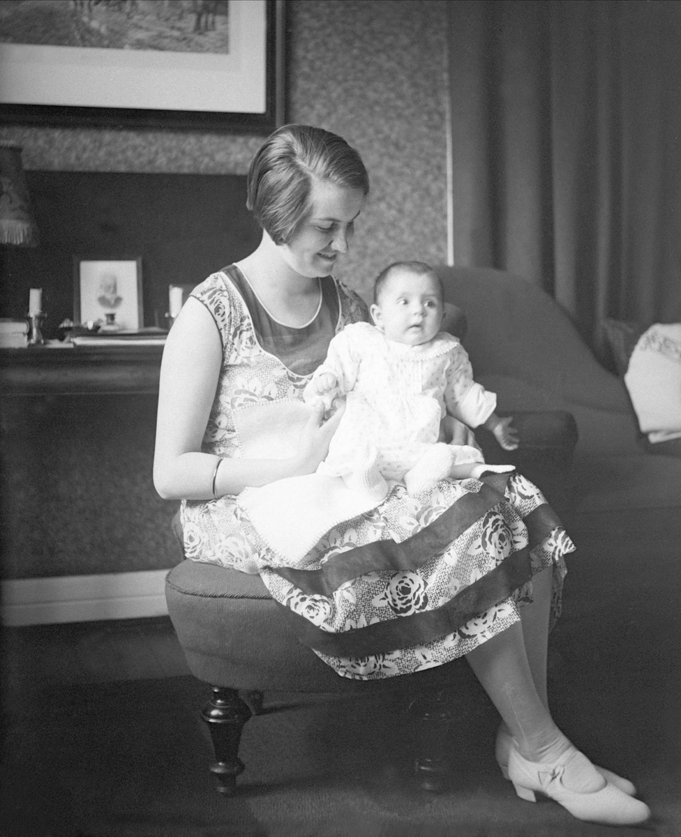 Dordi Arentz sitter med sin datter på fanget. Fotografert juni 1929.