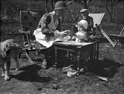 Moren Dordi Arentz sitter i hagen og mater sin datter Siri s