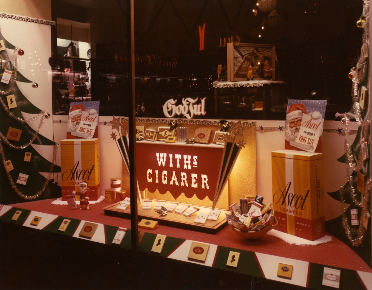 Vindusutstilling med reklame for bland annet Ascot sigaretter hos Knut Endregård Tobakkforretning i Oslo.