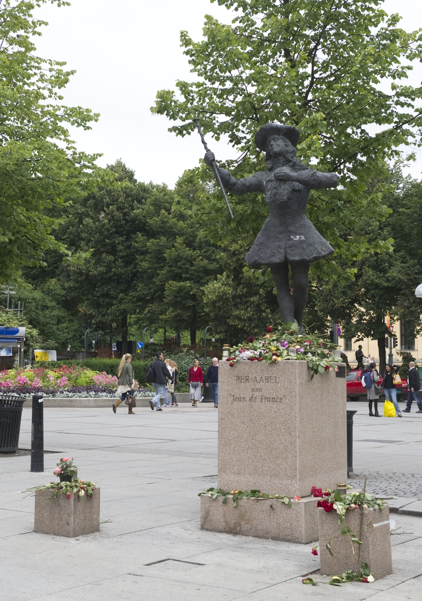 "Sorg i det offentlige rom". Nina Sundbyes statue av Per Aabel foran Nationaltheatrets hovedinngang dekorert med blomster, lys og hilsener.
