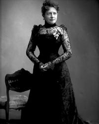 Portrett, kvinne i svart kjole med chiffonermer. Fru Erbe.