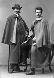 Gruppeportrett, to herrer med slengkapper og barter. Herrene