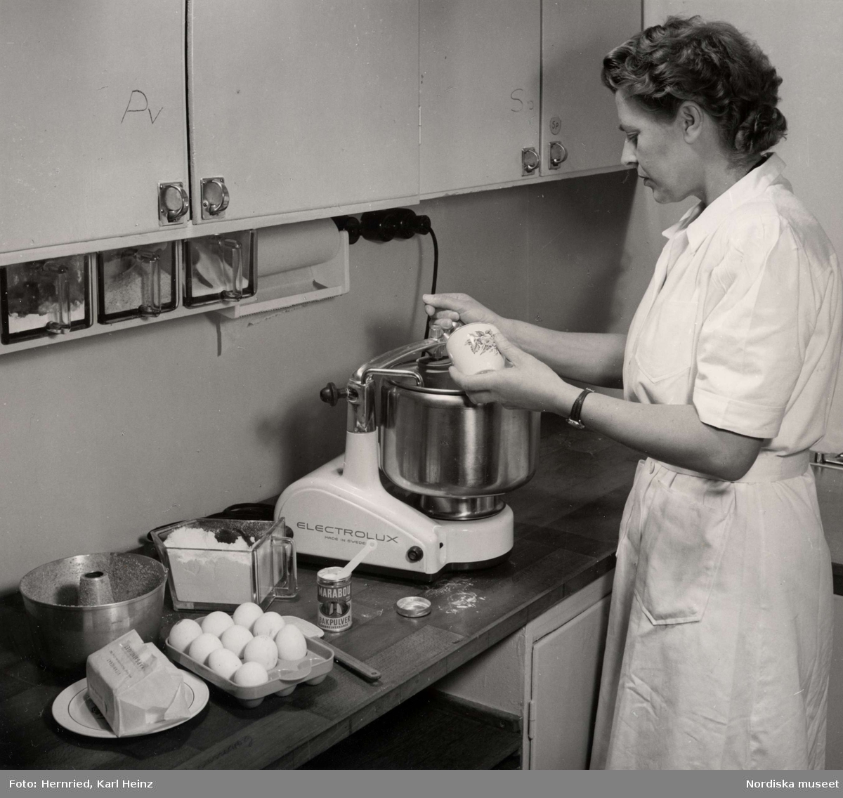 Kök. Kvinna bakar med en Electrolux hushållsassistent.