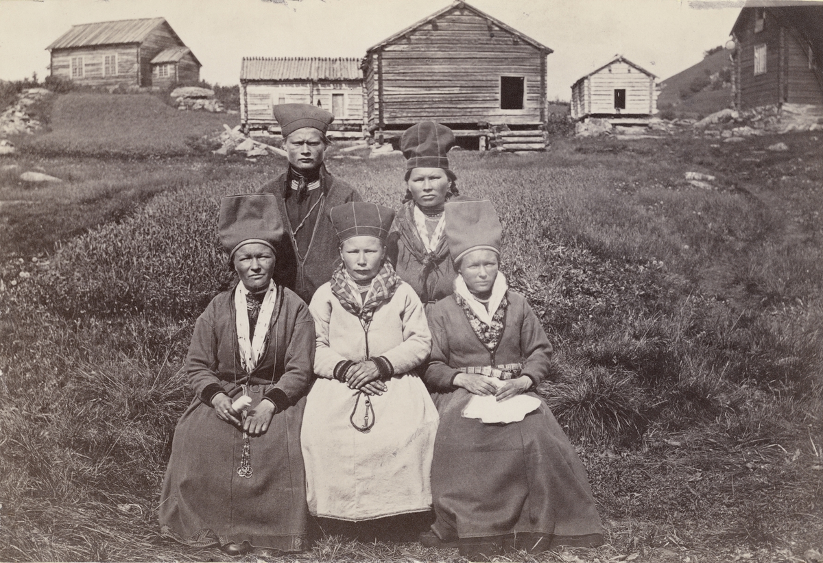 Gruppbild. Fem kvinnor framför timrade byggnader i Ammarnäs juli 1871.