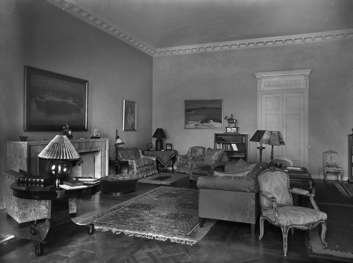 Interiör från Haga slott i Solna socken utanför Stockholm. Vardagsrummet möblerat med stoppade sittmöbler framför den öppna spisen.