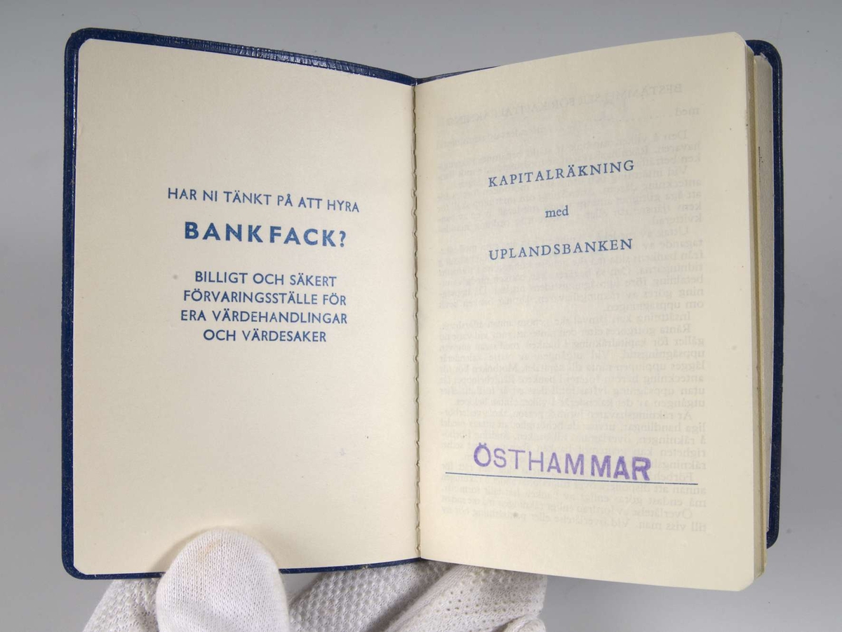 Blå bankbok av plast, en läderimitation. Uplandsbankens logotype på framsidan.