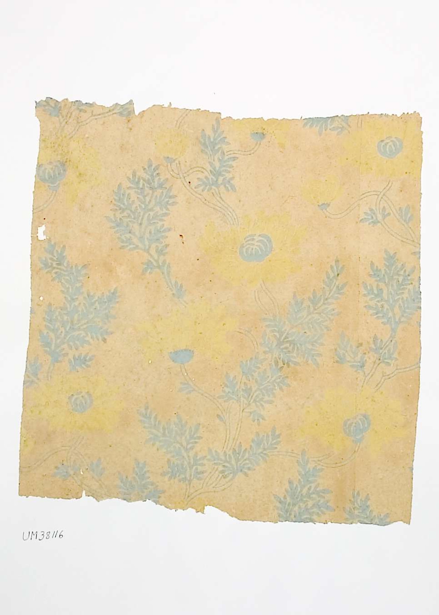 Tapetprov med tryckt mönster i gult och gråblått. Handskriven text på baksidan av kartongen:
251
Håga Herrgård
4.