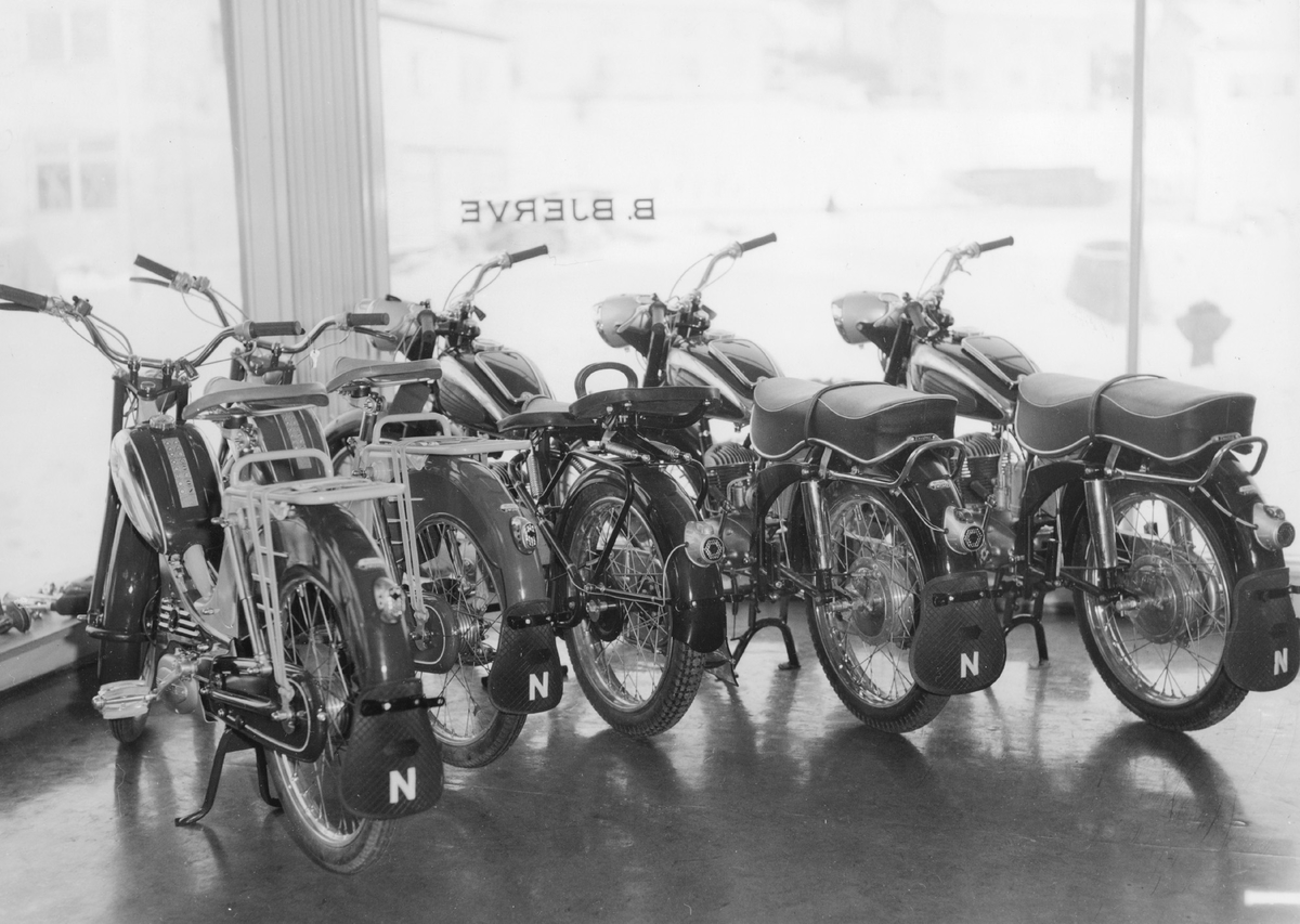 Forhandlers butikk: motorsykler og mopeder i et butikkvindu