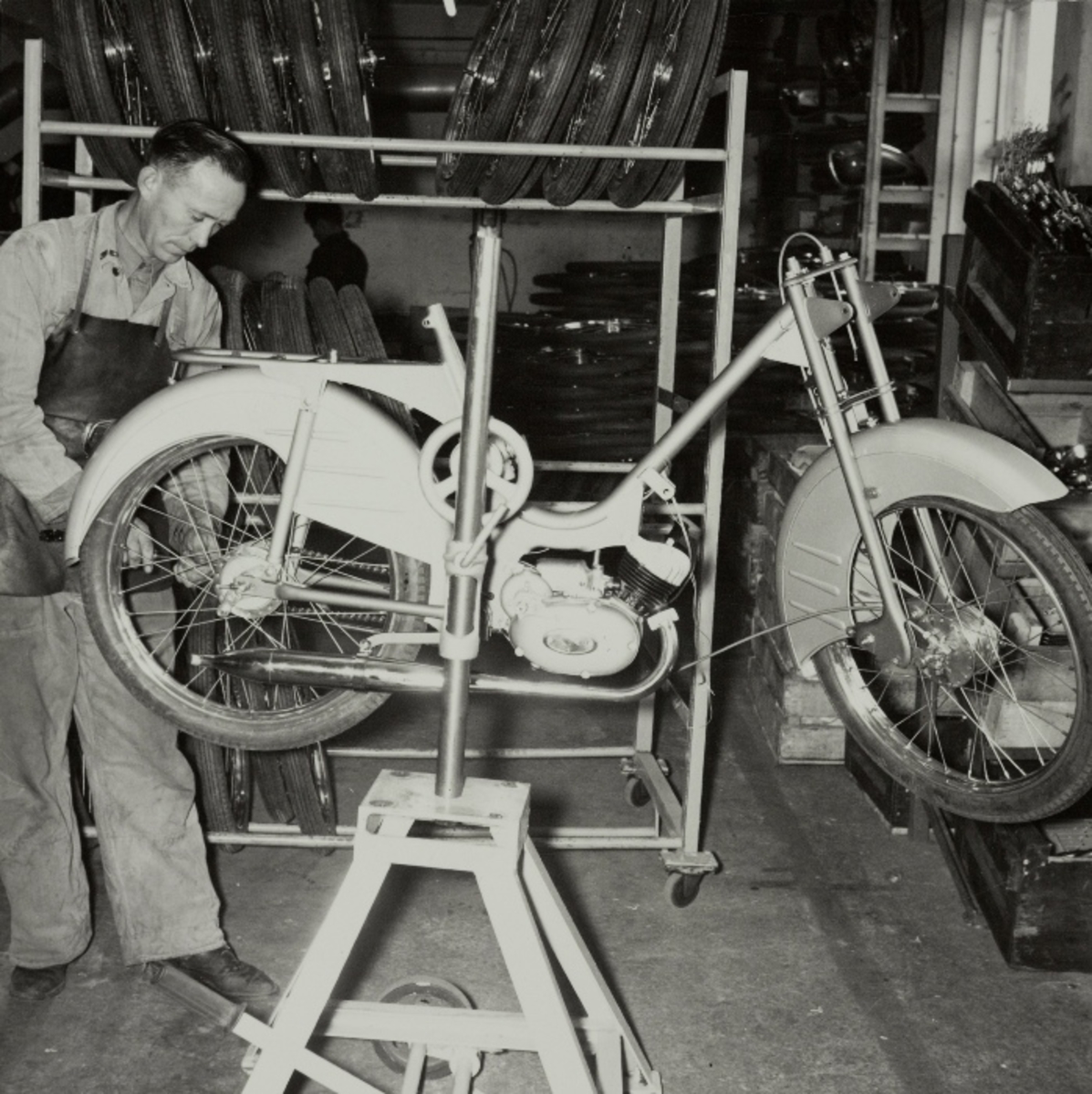 Ola Tjelta monterer hjul, kjede og kjedekasse på en TEMPO-Lett moped.