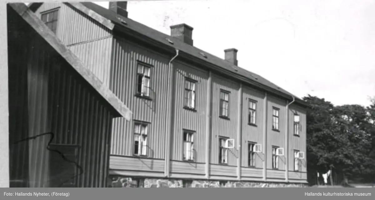 Äldreboende. Kv Åkaren 13. Bostad. Bilden har varit publicerad i Hallands Nyheter, 1947-12-04, "Pensionärshemsbygget  på "Reträtten" har påbörjats". Byggnaden, som uppfördes 1864 efter den stora stadsbranden året innan, fungerade som nödbostäder för de hårdast drabbade. Ganska snart efter kom det att fungera som ett fattighus. Det revs1947 och på rivningstomten uppförde staden sedan pensionärshem med 48 små lägenheter.