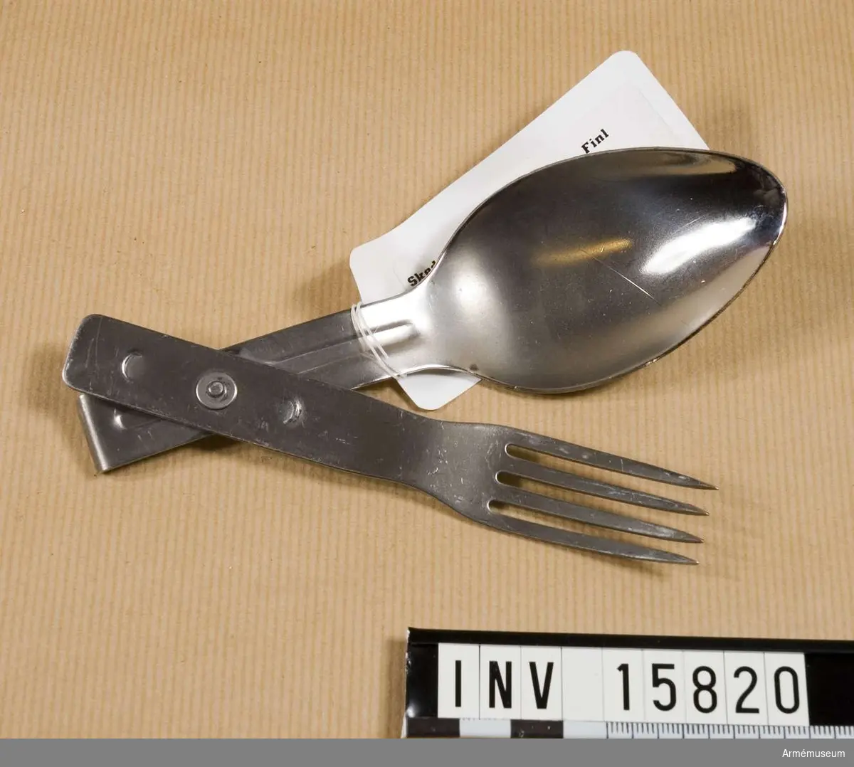 Grupp C II.
Sked- och gaffelkombination av rostfritt stål, som kan  sammansättas för fältutrustning. Skeden och gaffeln sammankopplade med en nit.