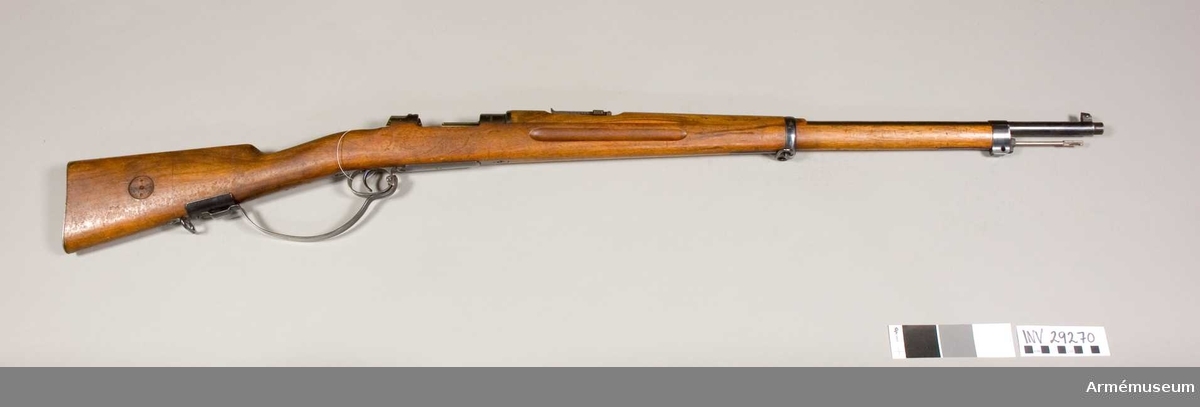 Grupp E II f.
Modellexemplar med extra "varbygel"  Gevärets tillverkningsnummer: 11003. Samhörande gevärsrem, vid geväret fästad fastställningslapp på vilken skriften delvis är oläslig.