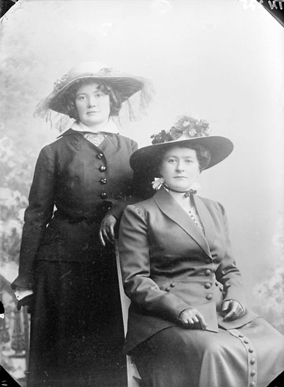 Enligt senare noteringar: "Ateljéfoto på två kvinnor, klädda i dräkter och stora hattar."