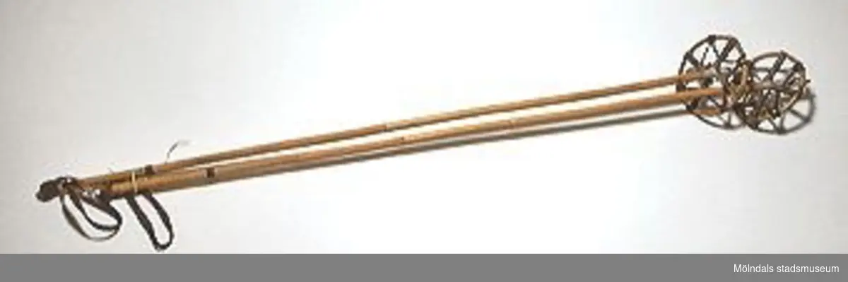 Skidstav av bamburör. Trygan består av rundböjd bambustav av klenare slag. Med hjälp av läderremmar är den fäst vid staven. Trygans diameter 163 mm.Givaren har själv använt stavarna.