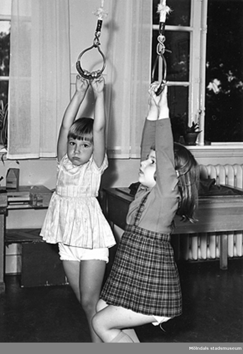 Två flickor i rep som hänger från taket vid Holtermanska daghemmet 1953.