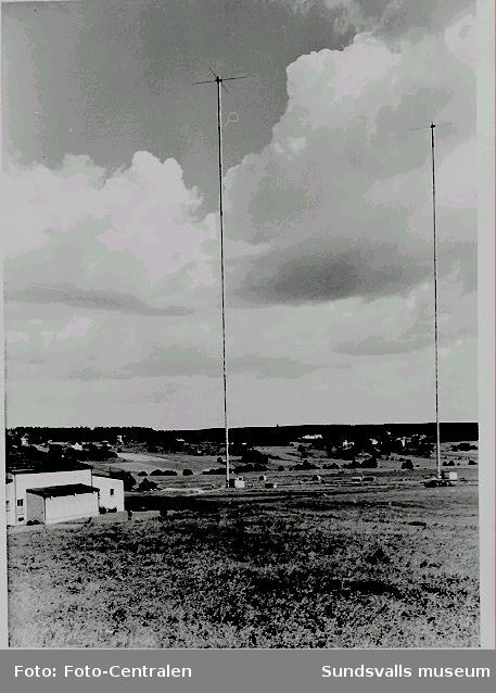 De två 222 meter höga rörmasterna, vilka togs i bruk 1953.T v rundradiostationen.