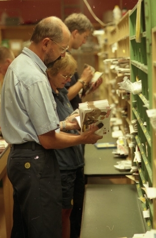 Posttjänstemän sorterar post inne i sorteringsdelen på en
postanstalt. Tillhör en dokumentation av en lantbrevbärare i trakten
av Valdermarsvik av fotograf Ove Kaneberg.