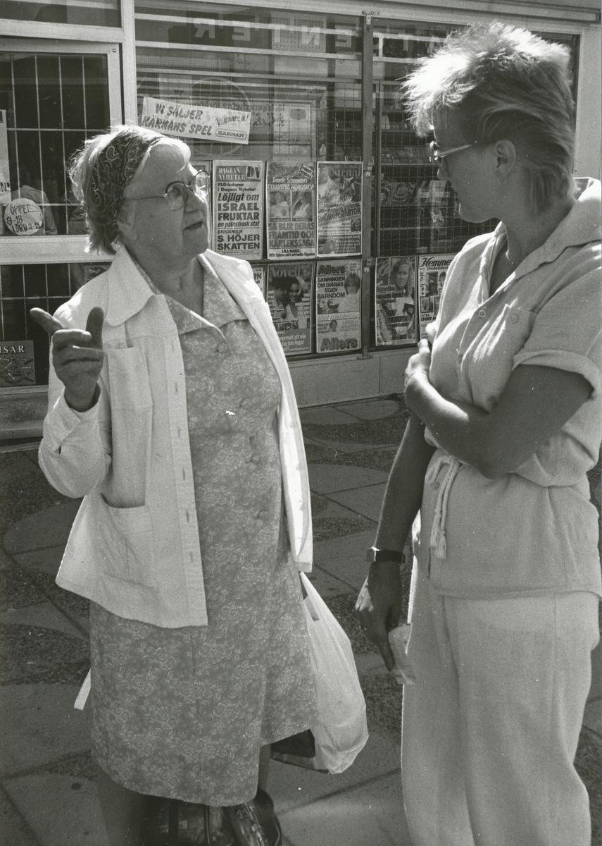 Utanför postkontoret Spånga 4 i Tensta Centrum träffar postkassör Anja Jamal till höger en kund, 1982.