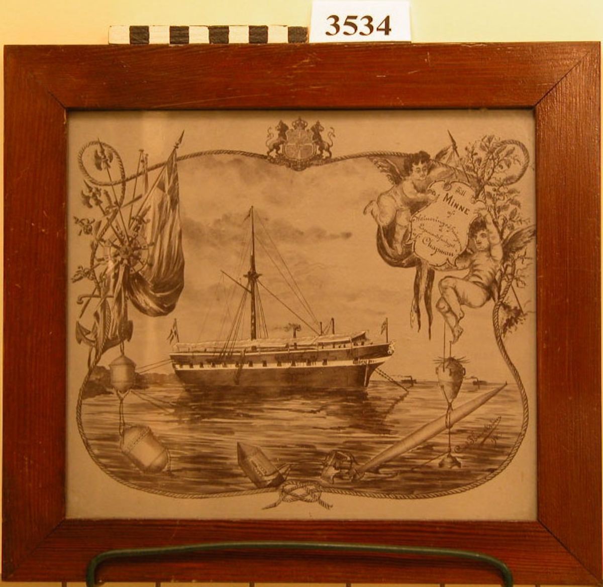 Fotografi, i glas och ram, av en teckning över logementsfartyget "af Chapman" till ankars i Aspö med mineringsskolan. Signerad Carl Thörnström 1895.