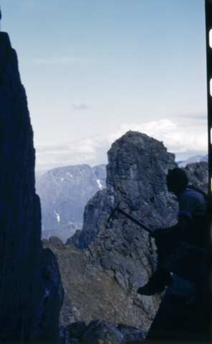 Fjellklatring. Mann med klatrehakke i silhuett i bratt fjelltopp  Hvor