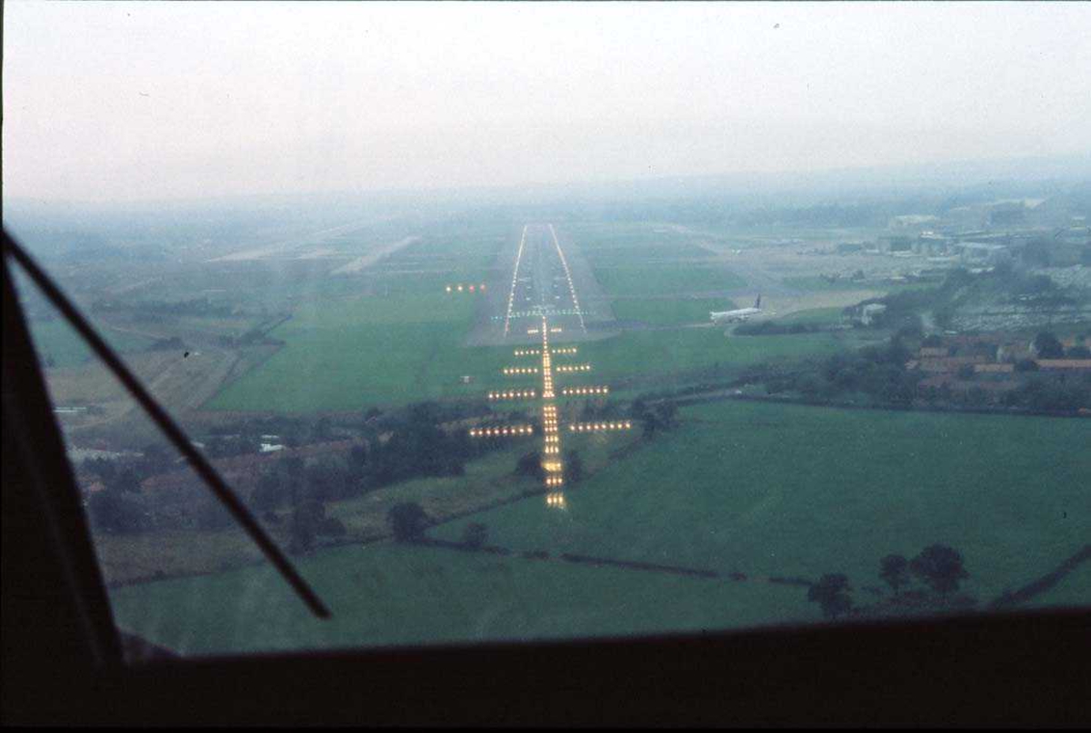 Lufthavn. Utsikt mot rullebane fra lufta, G-EMBF fra British Regional Airlines.
