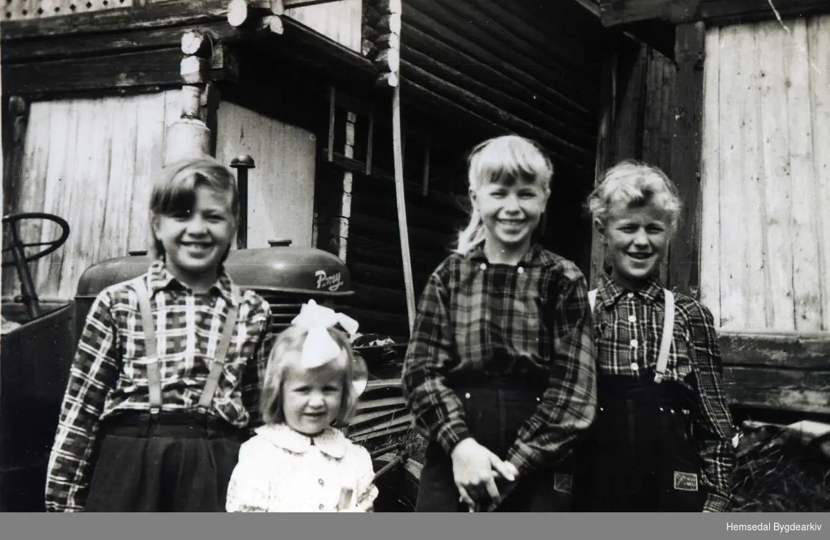 Frå venstre: Margit Ulsaker, Else Karin Ulsaker, Anne Ulsaker og Gunvor Ulsaker
I bakgrunnen den fyrste traktoren på garden, ein Massey Harris ponny, kjøpt i 1952.