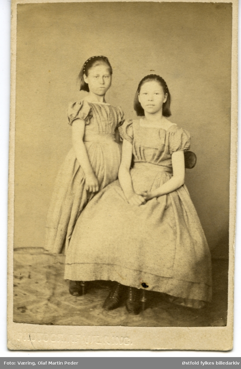 Visittkort av søstrene Anna og Janna Larsen, døtre av bokholder Christian L. Larsen og kona Marie (f. Venzentz i Holmestrand)
Familien bodde på Ferjestan (bygning på Borgarsyssel Mseum), før lå bygningen ved Sundet, Solli i Tune.

Faren var bokholder på Soli Brug.
Det ar 8 søsken i familien (1865) og
Anna født ca 1853 (13 år i 1865), Janna født ca 1857 (8år i 1858).