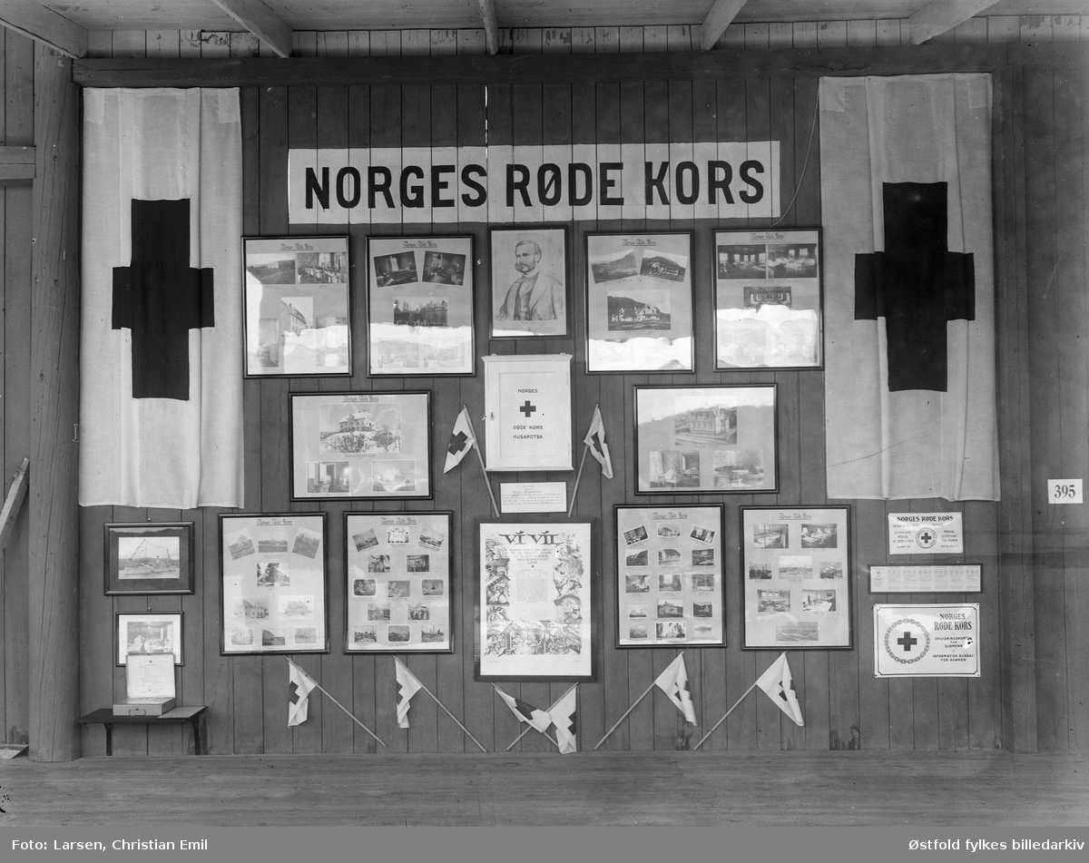 Østfoldutstillingen i Sarpbsborg 1930.
Veggutstilling for Norges Røde Kors med innrammede fotografier, flagg og vimpler.