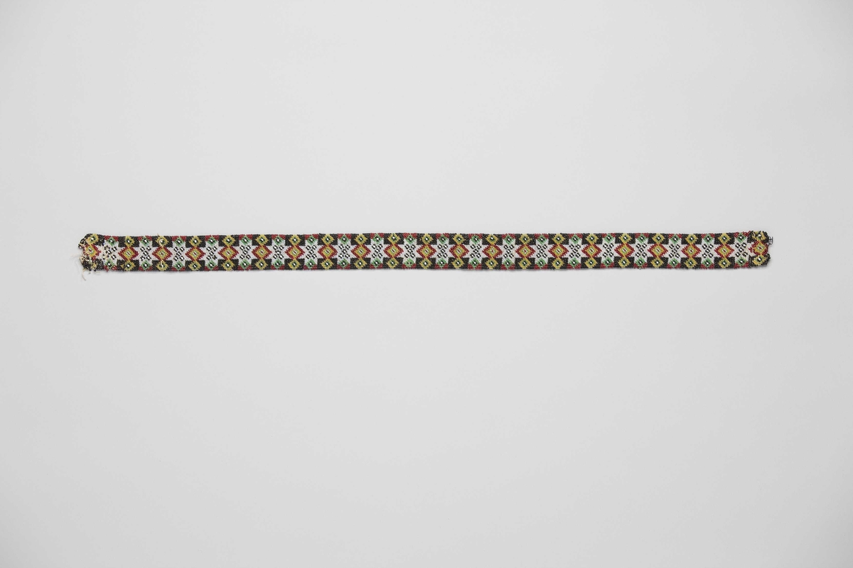 Perler i 8-bladsmønster med tre ståande firkantar mellom, i rapportar på 3,7 cm. 20 åttebladsroser.