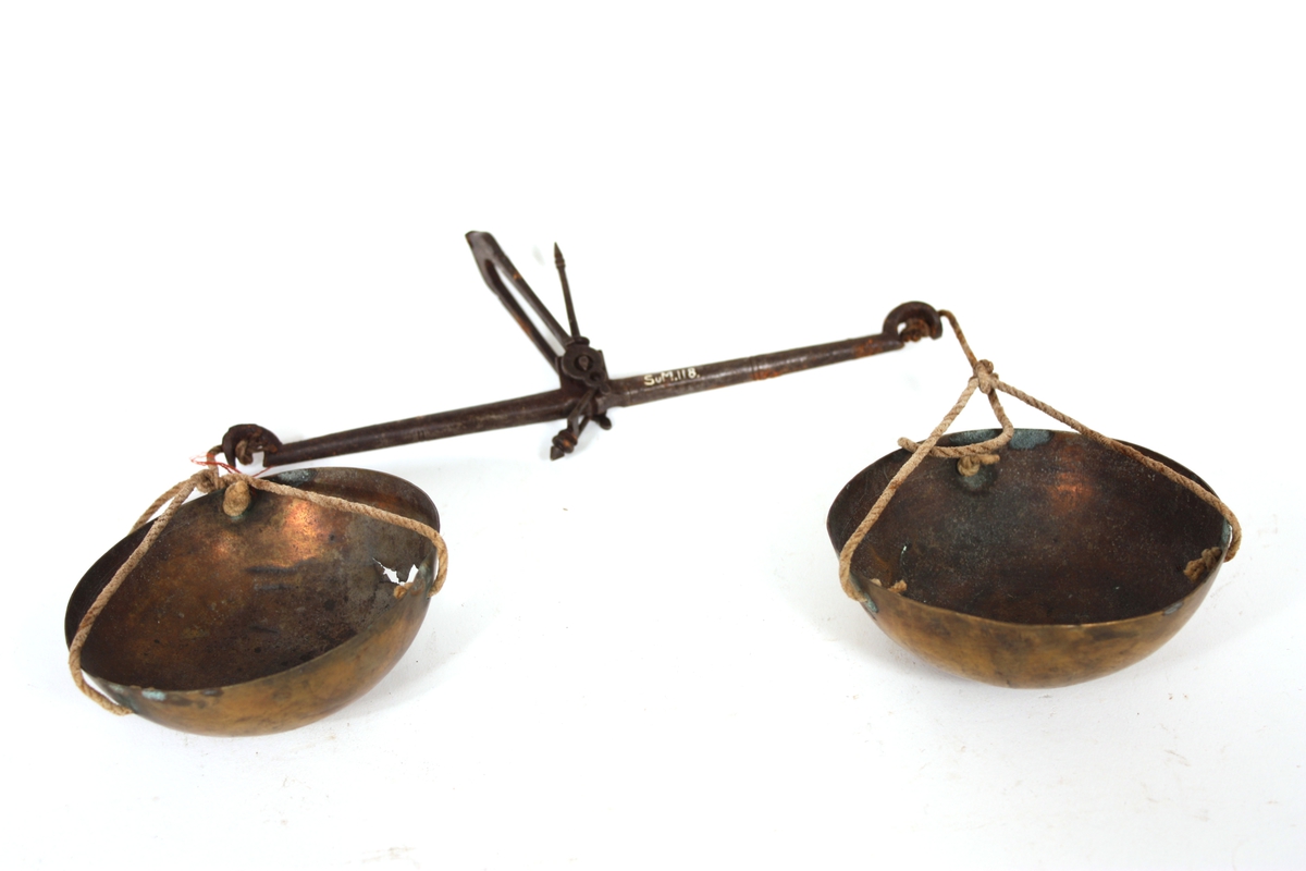 To smessingskåler festet med tau til vektstang av jern