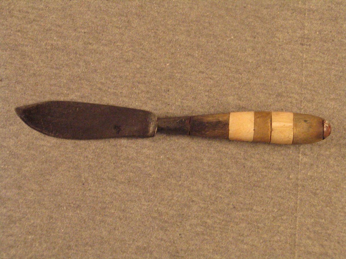Kniv med breitt blad og skaft av ringar i vekselvis bein og horn