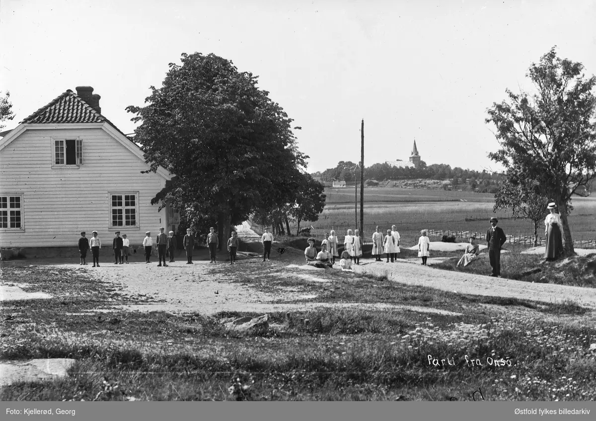 Parti fra Onsøy ved Fredrikstad.  Klokkergården (i dag Ørmenveien 5). Skolebarn. Onsøy kirke i bakgrunnen, innviet 1888.