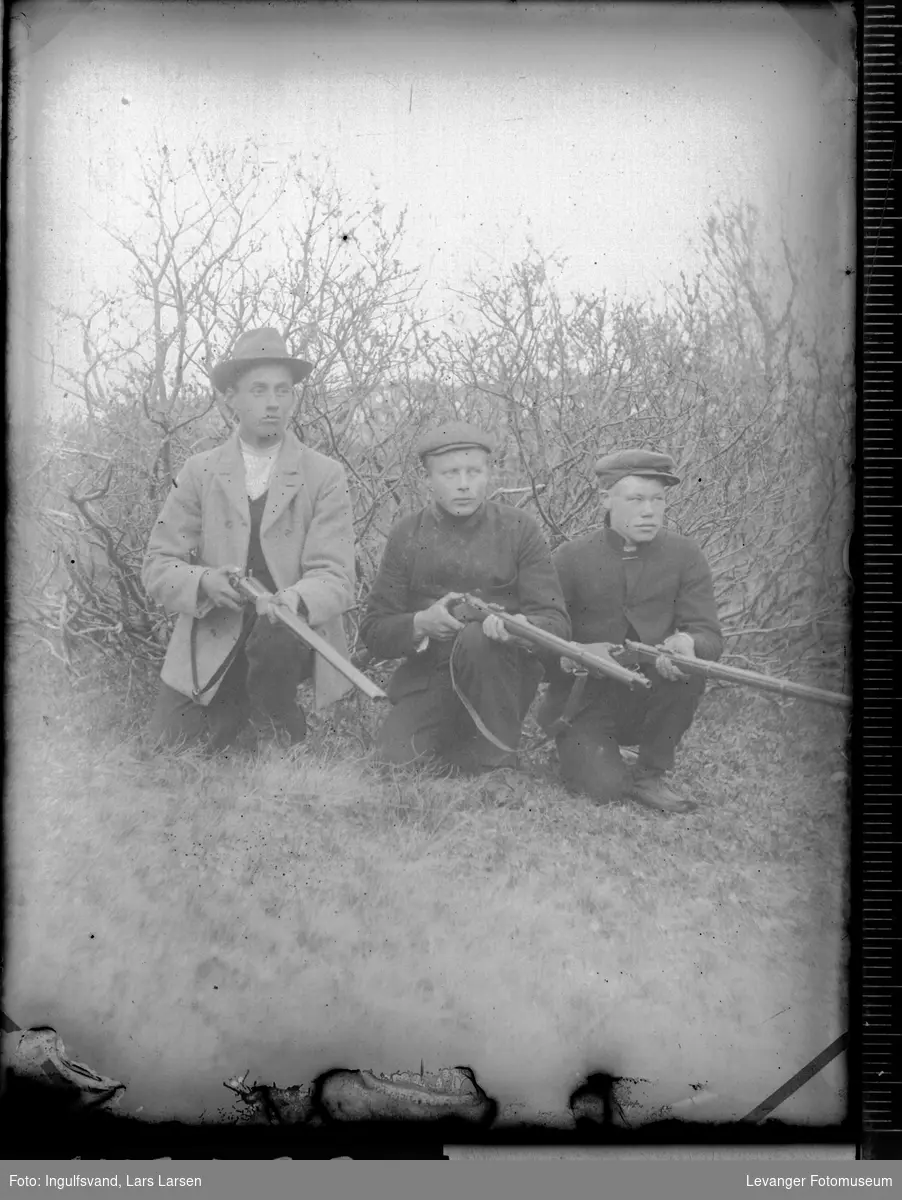 Gruppebilde av tre menn med geværer.