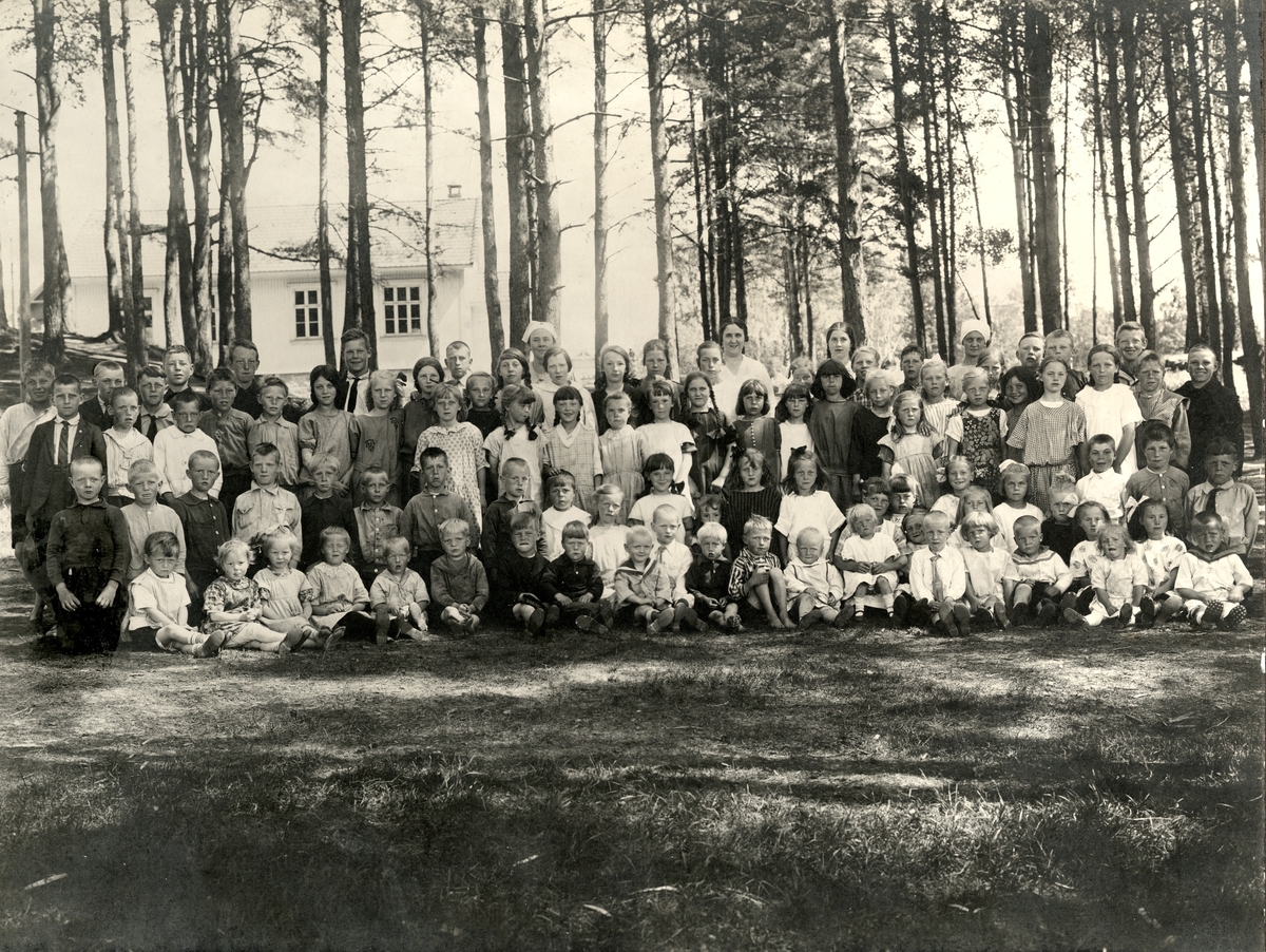 Skolebespisning på Borgestad 1924. Skolebespisningen ble arrangert av Gjerpen Røde Kors for at barna skulle få mat under storstreiken i 1924. Fru Anne-Margrethe P. Knudsen fra Borgestad (lys kjole, uten hodeplagg) og datteren, Gudrun (med fletter), ses i bakre rekke. Det var grøt på lørdager.