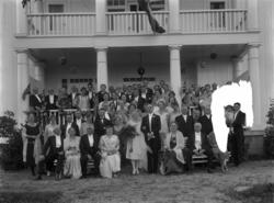 En gruppe mennesker fotografert utendørs i et bryllupsselska