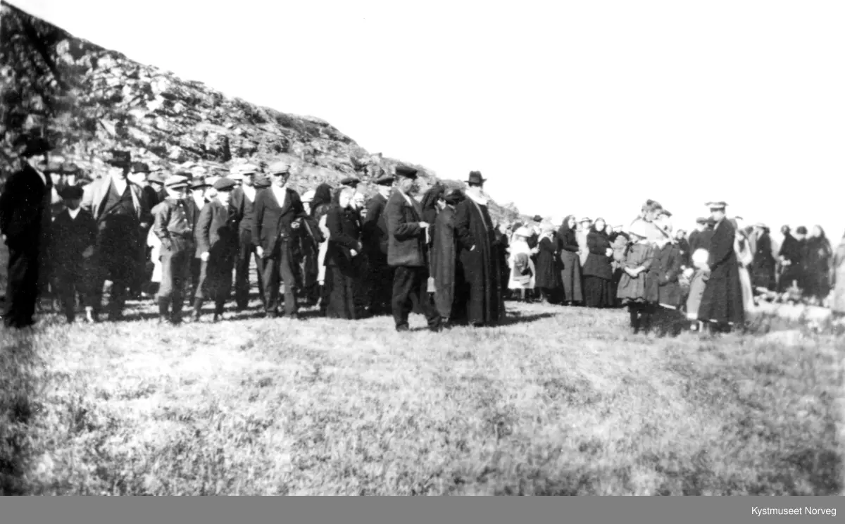 Valøya Kirkegård med prest og menighet, foran fra venstre: Olaf Olaussen Valø, Konrad Thomassen, guttene er ukjente, Hartvik Johansen, Arnt J. Storsul, Laura Gabrielsen, Hilmar B. Fjukstad, Harald P. Valø og presten. Bak fra venstre: Jon Hattevik Johansen med hest, med hvit hatt Ole Houm, omtrent midt på bilde står en dame med svart halstørkle, jakke og fotsidt skjørt er Andrea Valø til høyre står en dame med mørk kåpe og hvit hatt som heter Mary Valø