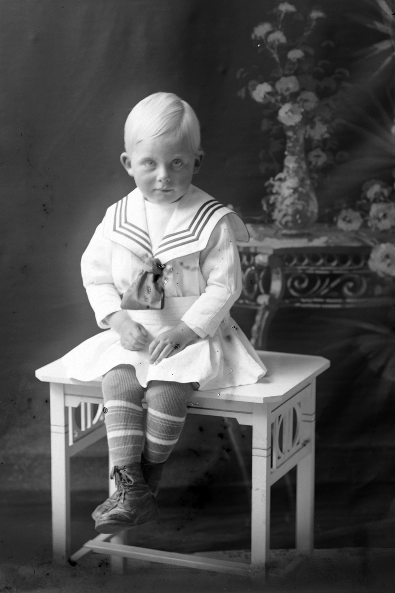 Studioportrett av et lite barn i helfigur, muligens Ivar Jacobsen.