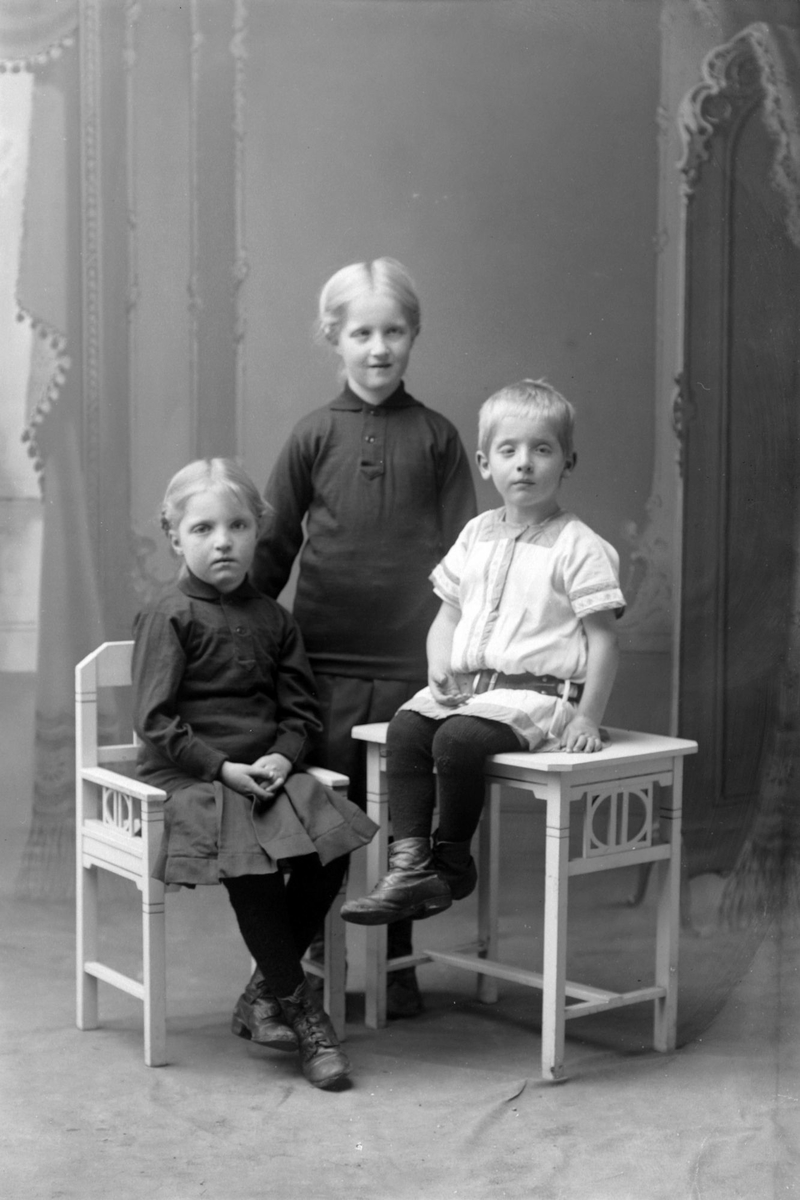Studioportrett i helfigur av tre barn.