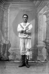 Studioportrett av en mann i en spesiell hvit drakt med et sk