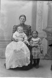 Studioportrett av en kvinne med to barn.