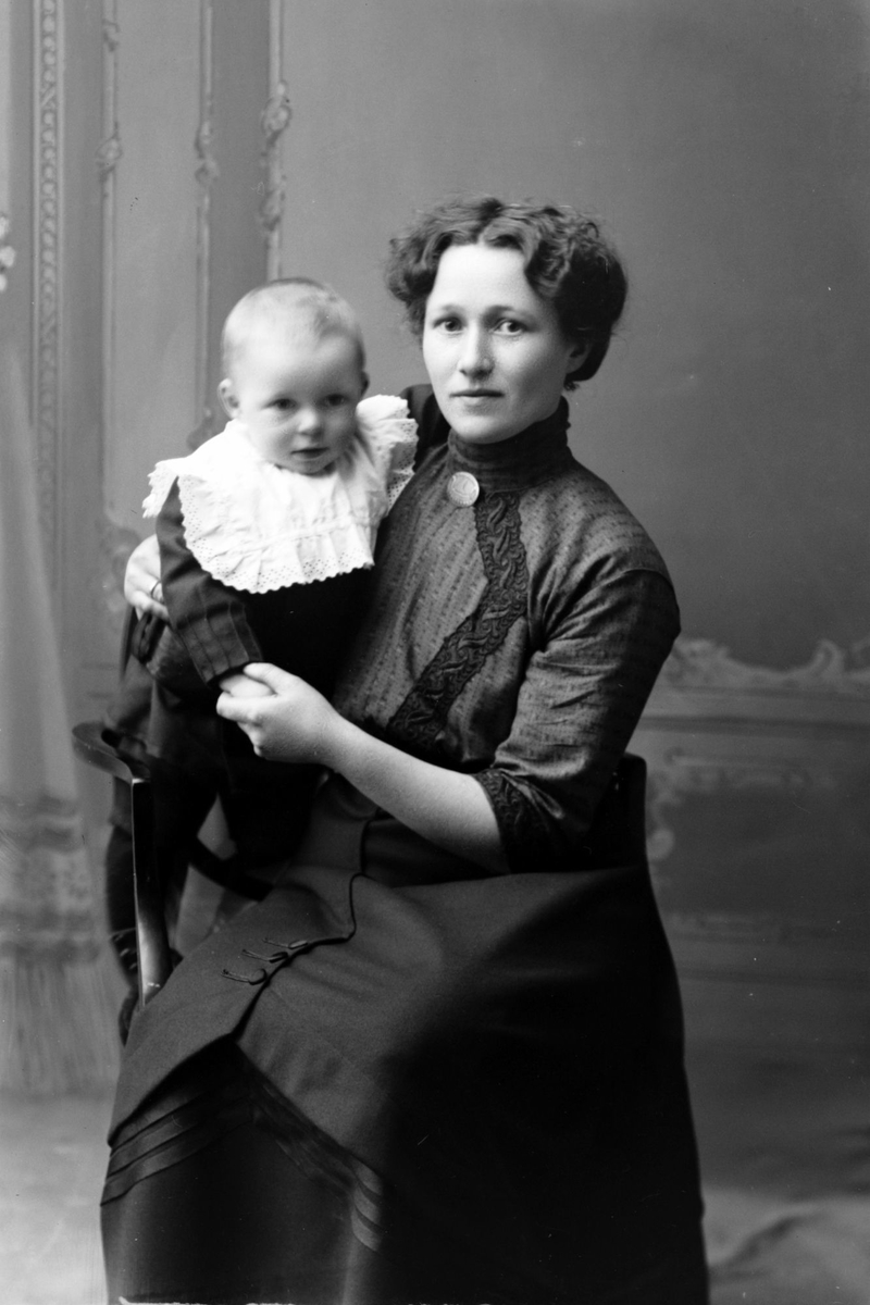 Studioportrett av en kvinne med et barn på fanget.