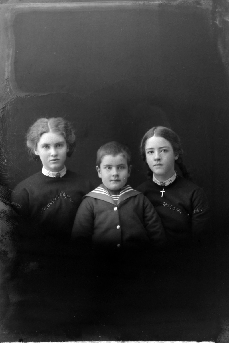 Studioportrett av tre barn i halvfigur.