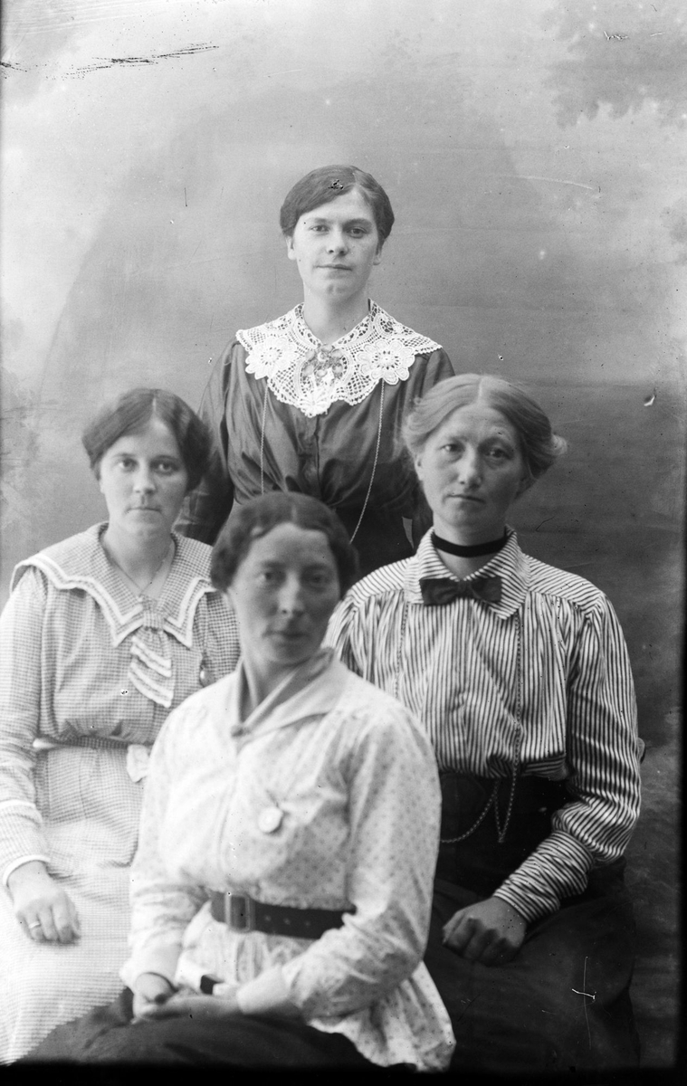 Studioportrett av fire kvinner.