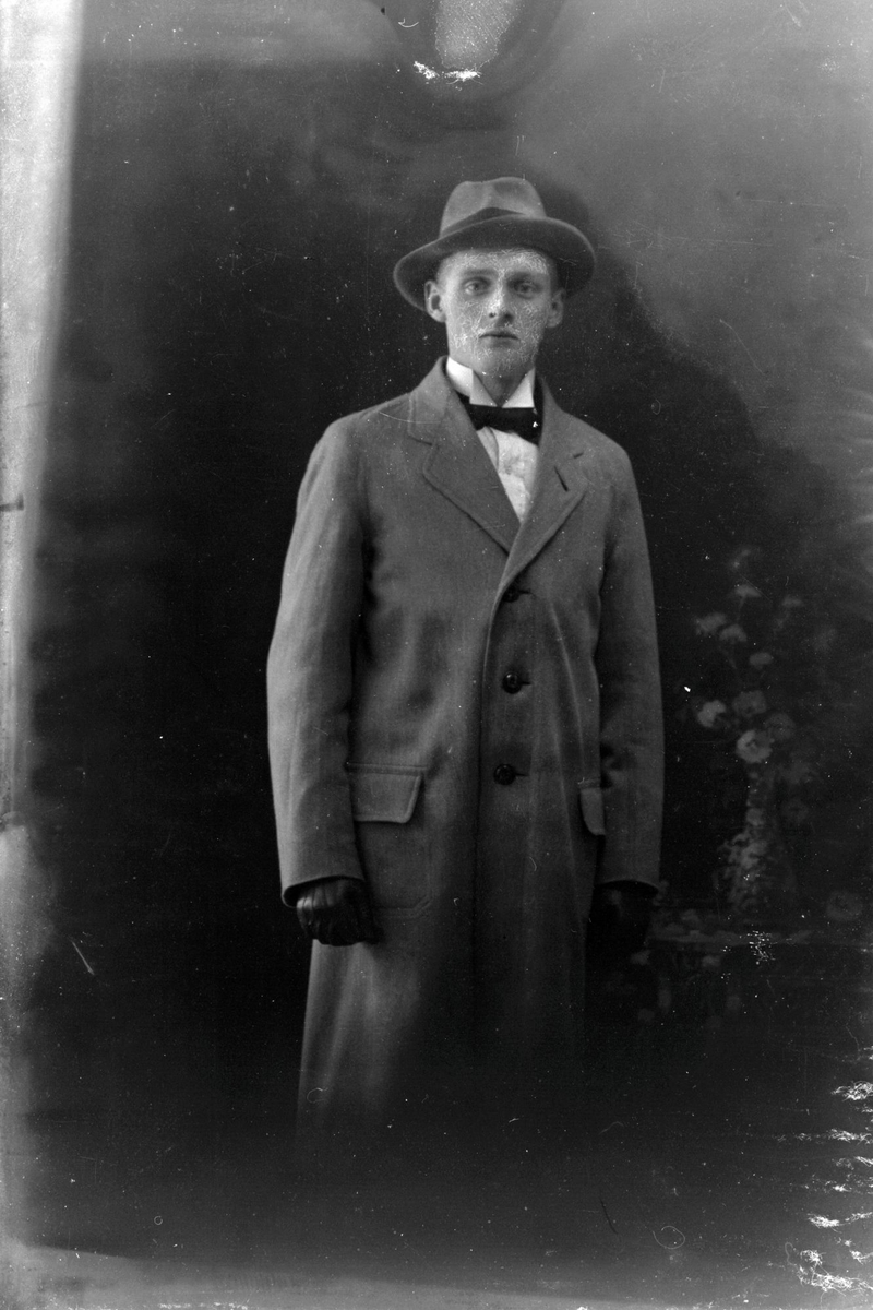 Studioportrett av en mann med hatt på hodet.