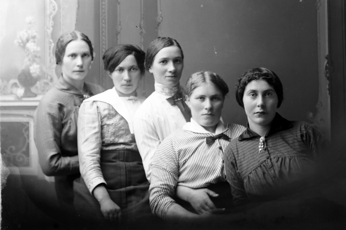 Studioportrett av fem kvinner på rekke.