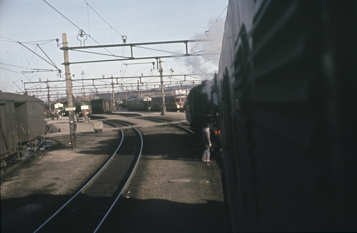 Fra Hamar stasjon. Tog til Rørosbanen, i midten tog fra  Gudbrandsdalen, skiftelokomotiv type El 10, fotografert fra førerrommet på et elektrisk lokomotiv type El 13.