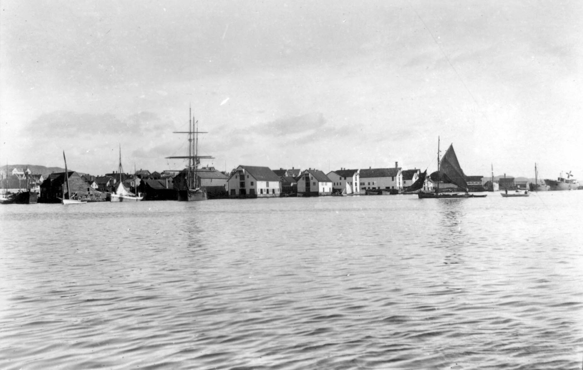 Risøy sett fra vest. Kortanes til venstre. Sjøhusbebyggelse med seilskuter og mindre båter fortøyd ved.